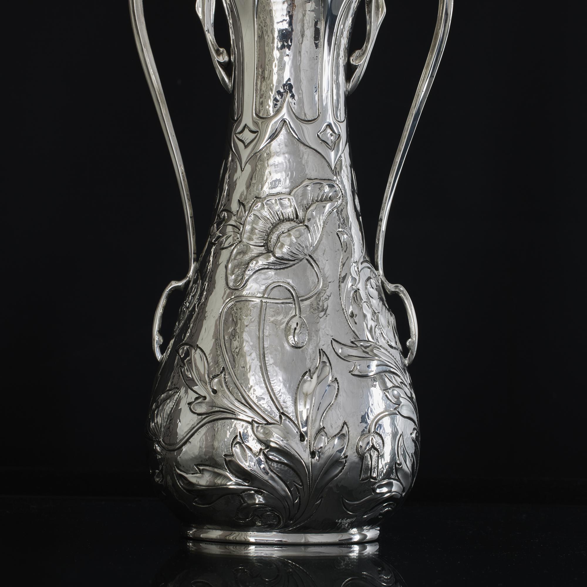 Pair of elegant Art-Nouveau-period silver vases with typical poppy flowers and foliage decorations embossed on the bodies, and flowing openwork tendril-shaped side handles.
 
 Weight: 601 g (19.32 troy ozs)