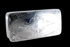 Silver snuff box w/ borders on the edge & a hinged lid w/ engraved floral motifs