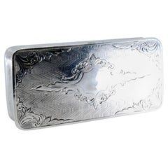 Silver snuff box w/ borders on the edge & a hinged lid w/ engraved floral motifs