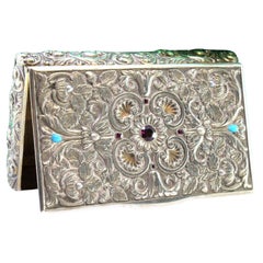 Silver snuff box w/ carved wreaths, hinged lid w/ colored stones & gold interior