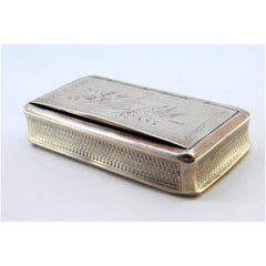 Tabatière en argent avec motifs floraux et oiseaux gravés, entourant une carte monogramme.