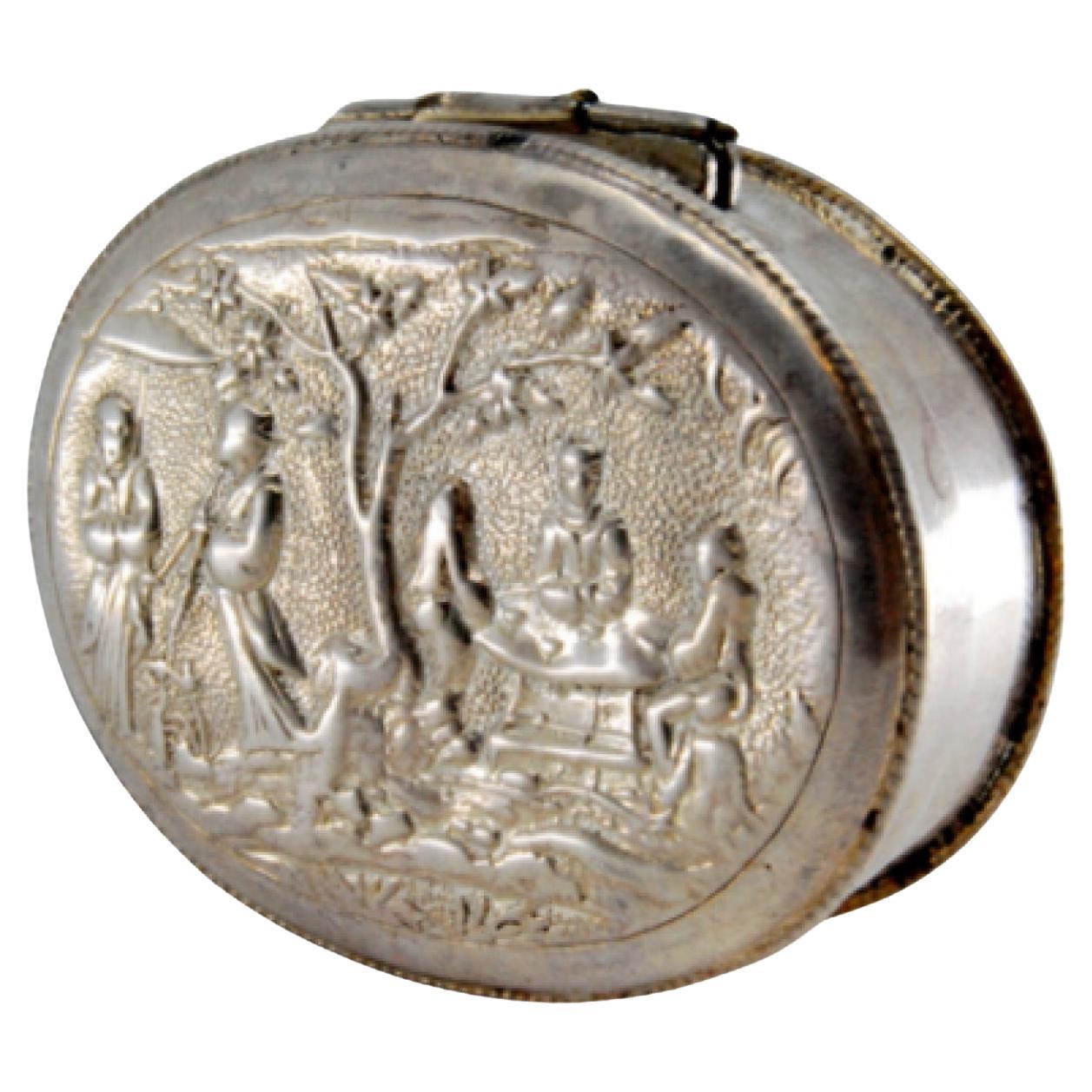 Descrizione: Tabacchiera in argento con motivi quotidiani in stile orientale in rilievo e coperchio a cerniera. Metallo: Argento. Origine: Orientale. Mark: Assente. Peso: 32,76 grammi. Dimensioni: 5,8x1,5 cm. Contenuto: 925/1000. Segno del saggio: