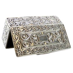 Silver snuff box with embossed floral motifs surrounding a monogram card