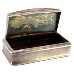 Silver snuff box with engravings surrounding a monogram card and a hinged lid