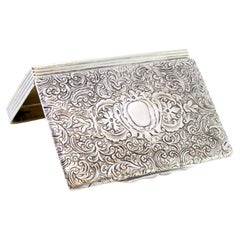 Silver snuff box with floral-engraved lid and fluted casing