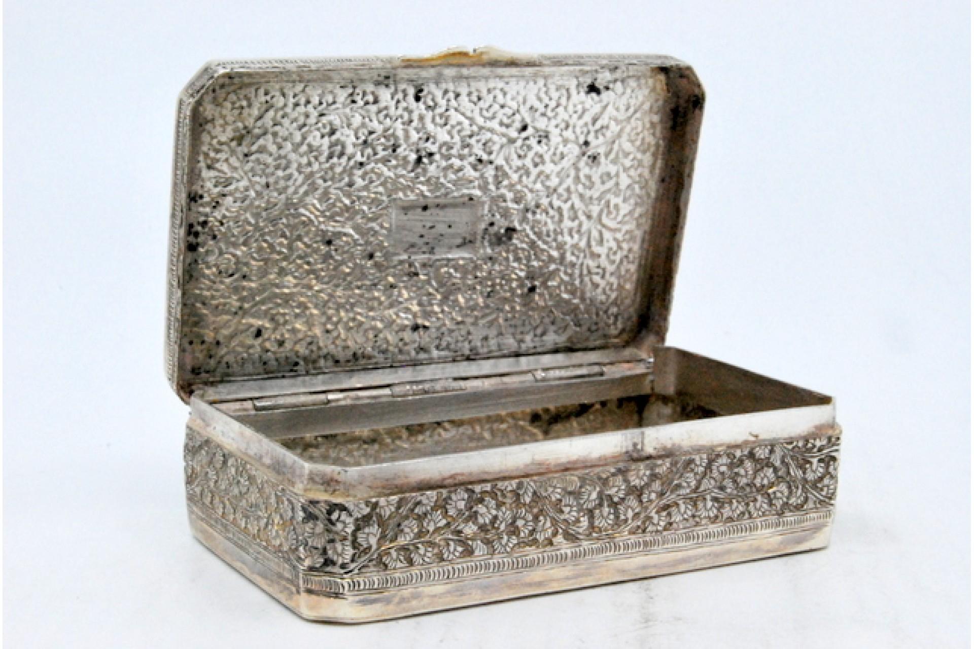 Description: Silver snuff box with embossed floral motifs on the hinged lid. Metal: Silver. Origin: Pakistani. Brand: Farouk Industries Karachi. Weight: 109.01 grams. Dimensions: 8.3x2.2cm. Content: 925/1000. Assay Mark: Absent. Additional