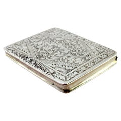 Silver snuff box with raised floral motifs, monogram card and hinged lid