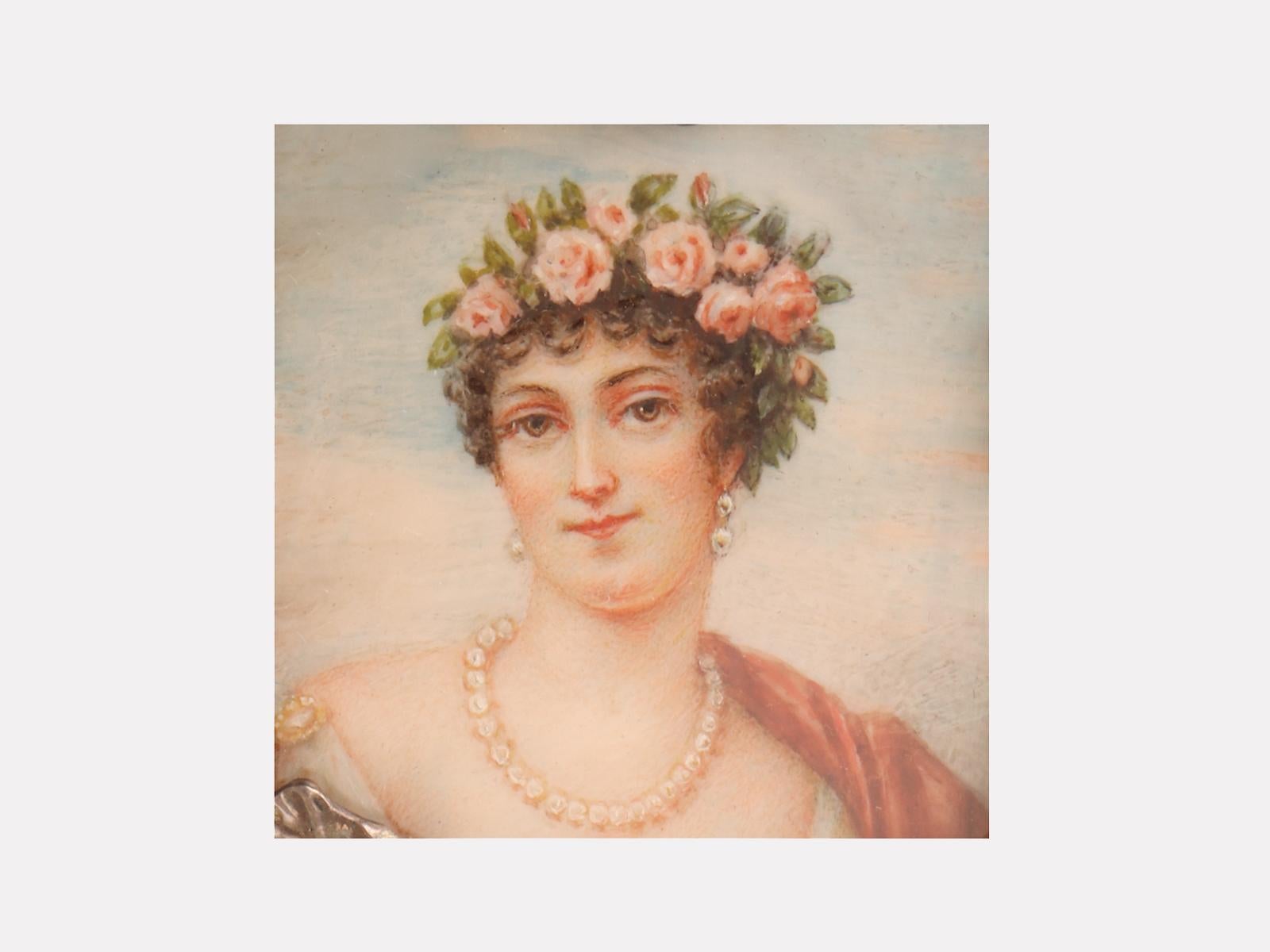 Runde silberne Schnupftabakdose mit geprägten Irisblüten. Die mit Aquarellfarben auf Elfenbein gemalte Miniatur zeigt eine Frau mit einer Rosenkrone im Haar und einer Perlenkette. Gezeichnet A. Baron. Frankreich, um 1900. (VERSAND NUR IN DIE EU)