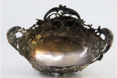 Silver soap dish with floral motifs and plant elements, set on four legs