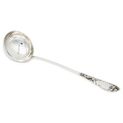 Silver soup ladle embossed on the handle