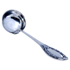 Silver soup ladle embossed on the handle involving a monogram cartouche