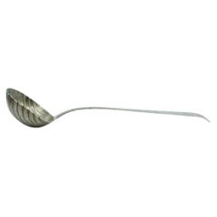 Silver soup ladle in the shape of a shell and handle to be shipped