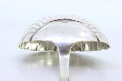 Silver soup ladle in the shape of a shell and smooth handle to be dispatched