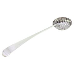 Silver soup ladle in the shape of a shell and smooth handle to be dispatched
