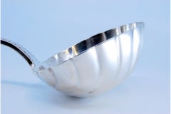 Silver soup ladle in the shape of a shell