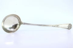Silver soup ladle w/ frieze & reliefs on the handle surrounding a monogram card