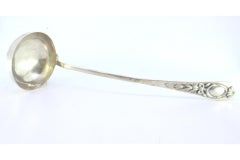 Silver soup ladle w/ frieze & reliefs on the handle surrounding a monogram card