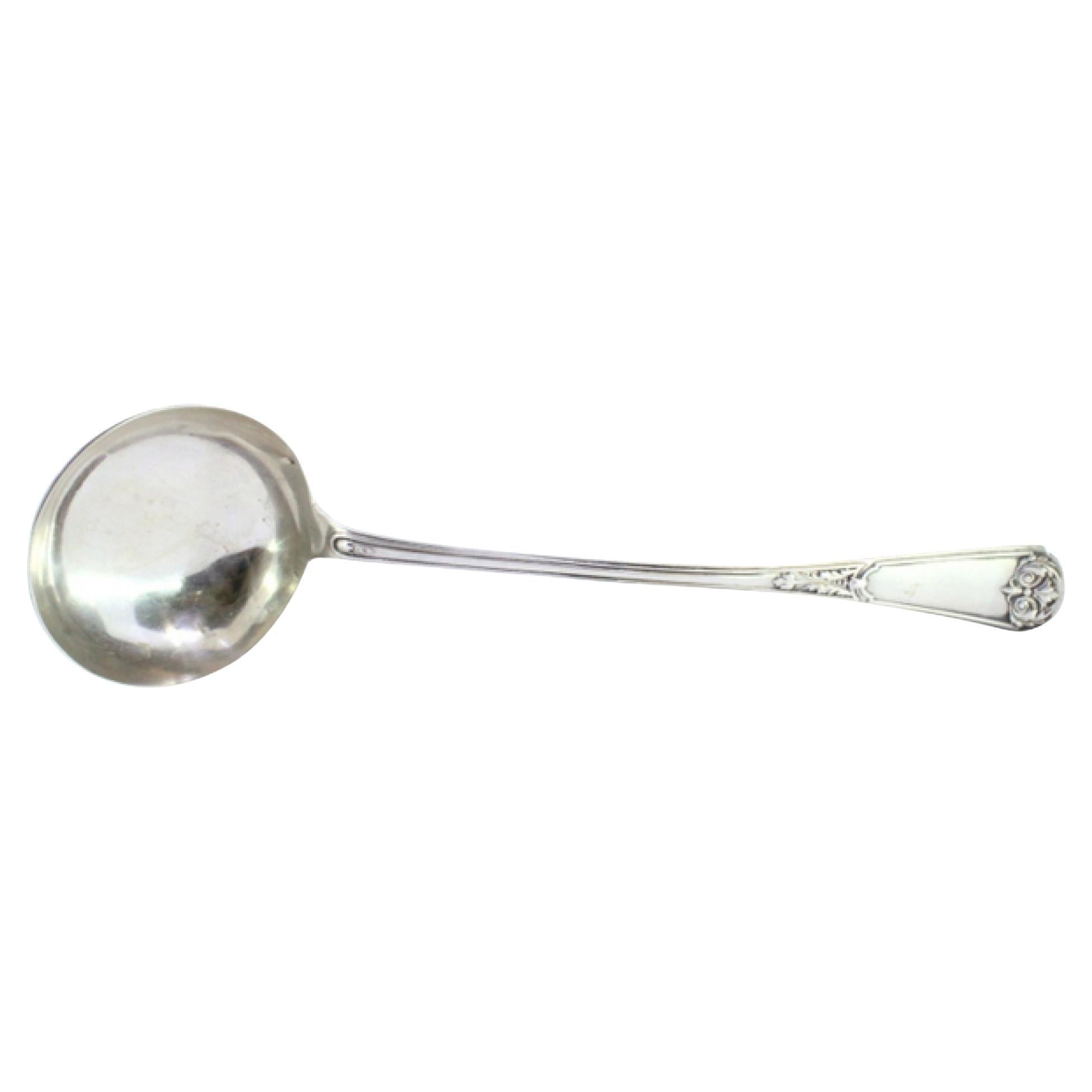 Silver soup ladle w/ frieze
reliefs on the handle surrounding a monogram card
