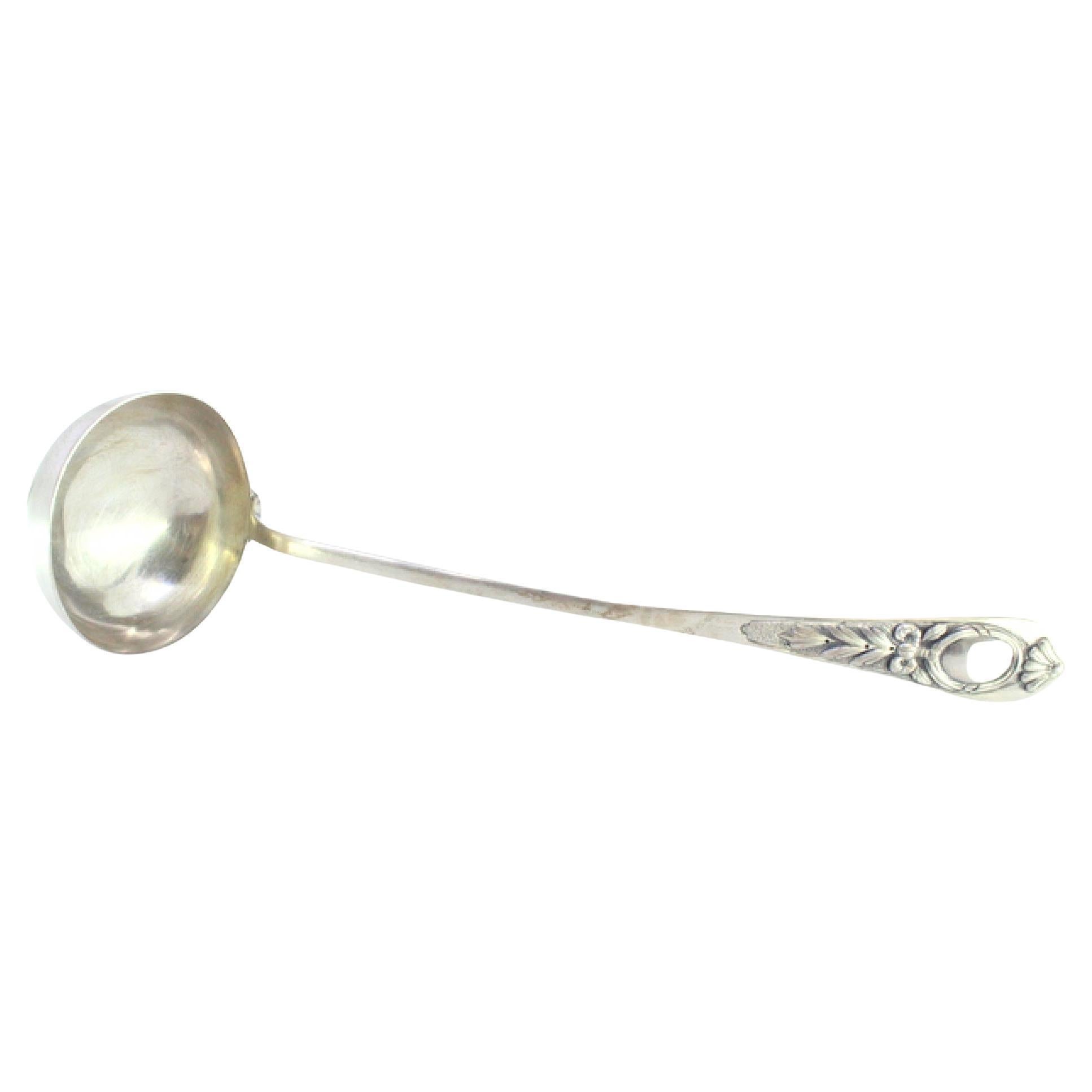 Silver soup ladle w/ frieze
reliefs on the handle surrounding a monogram card