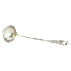 Silver soup ladle w/ frieze
reliefs on the handle surrounding a monogram card