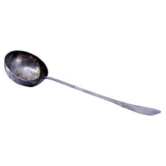 Silver soup ladle w/ friezes & palms on the handle surrounding a monogram card