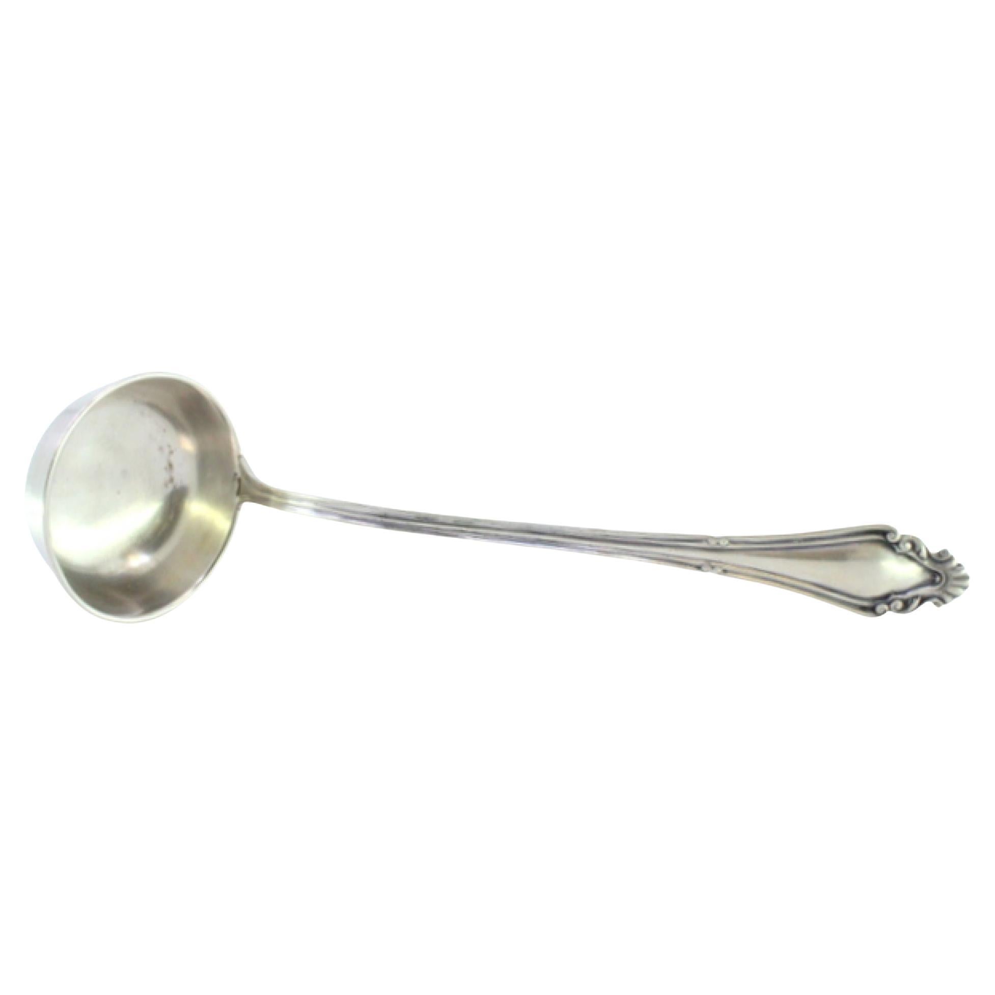 Silver soup ladle w/ friezes
reliefs on the handle surrounding a monogram card