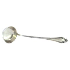 Silver soup ladle w/ friezes
reliefs on the handle surrounding a monogram card