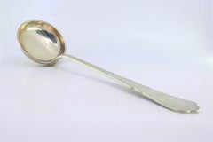 Silver soup ladle with a groove along the scalloped handle