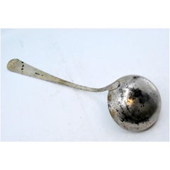 Silver soup ladle with a strip along the handle
