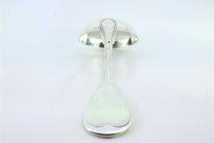 Silver soup ladle with a strip along the handle