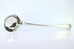 Silver soup ladle with a strip along the handle