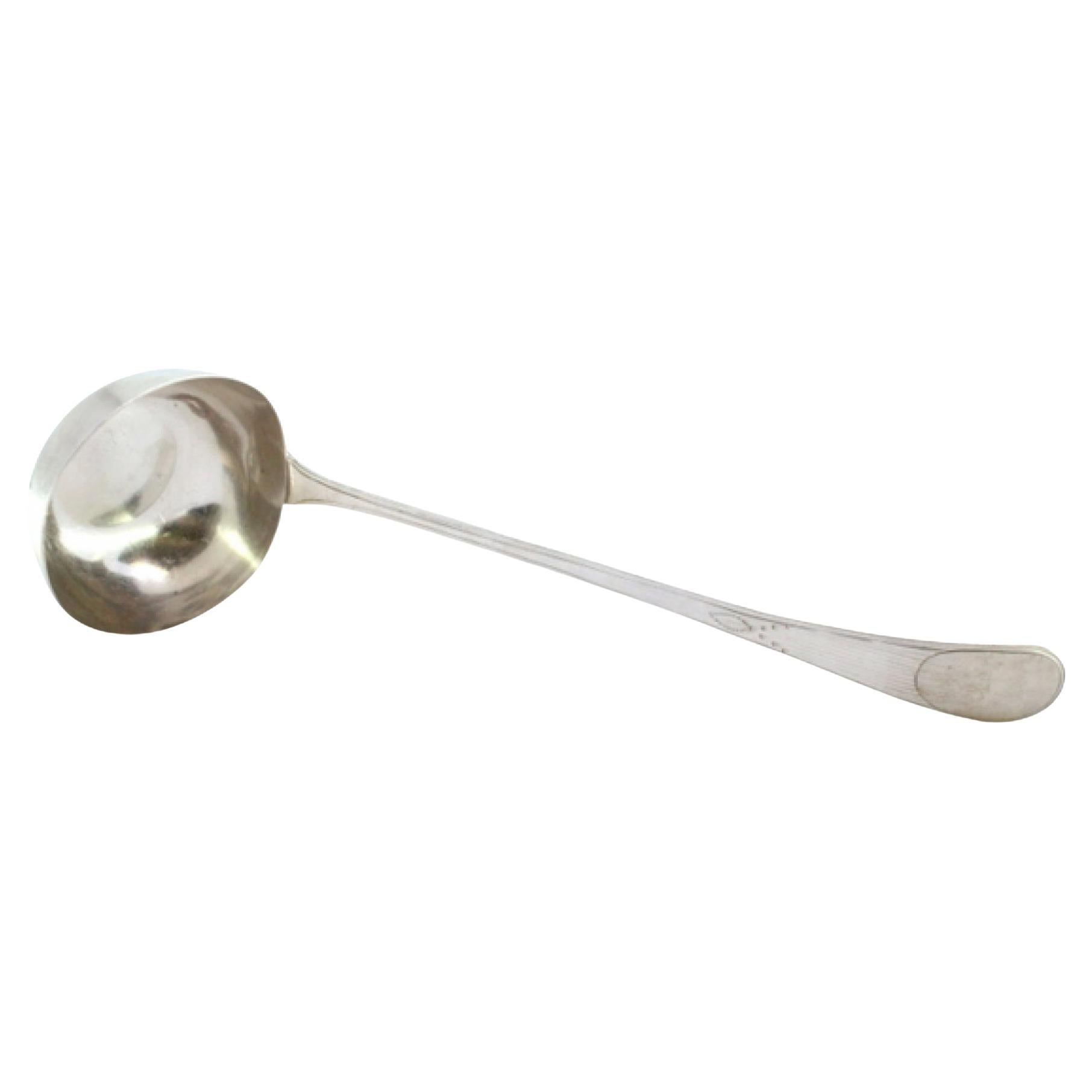 Silver soup ladle with crimped handle surrounding monogram card