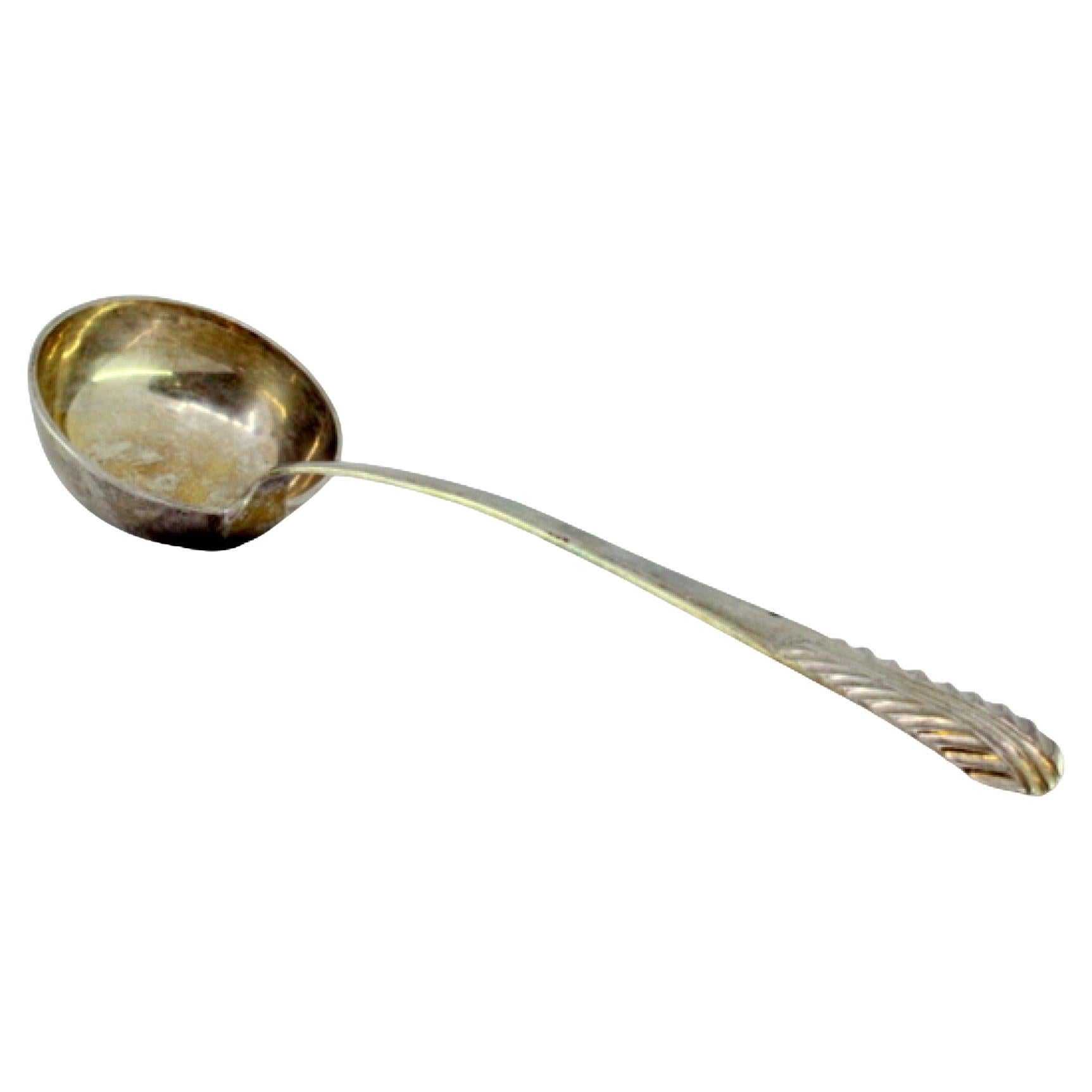 Silver soup ladle with embossed handle