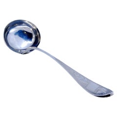 Silver soup ladle with floral motifs engraved on the handle and a monogram card