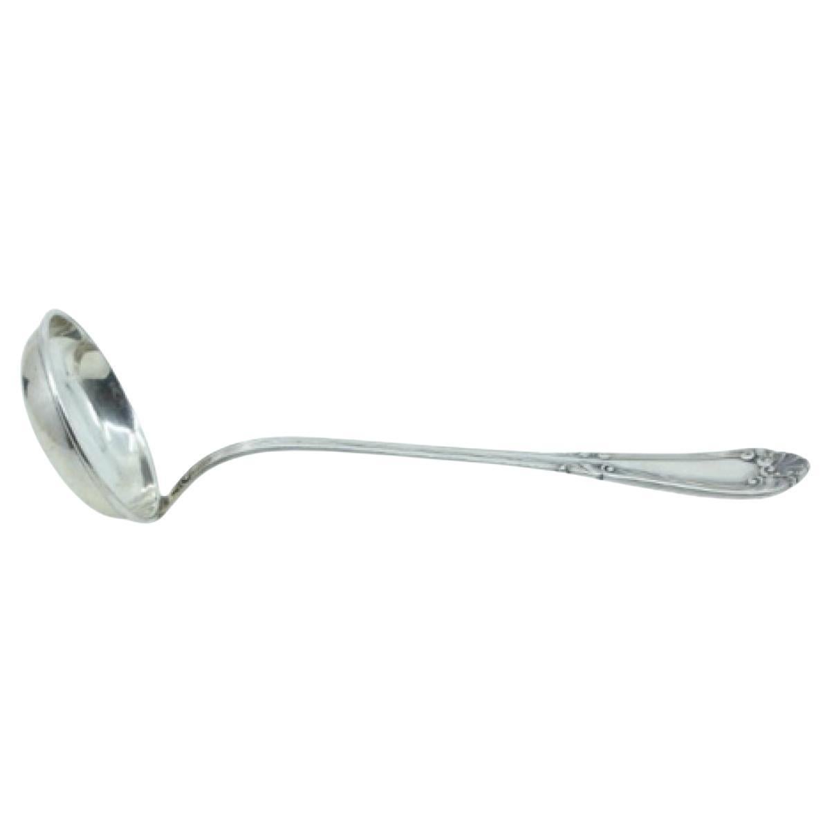 Silver soup ladle with friezed handle and scrolls around a monogram