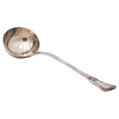 Silver soup ladle with friezes along the handle and relief