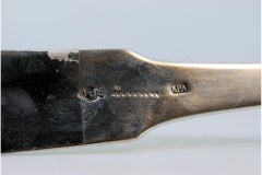 Silver soup ladle with grooves along the handle and embossed shell