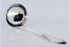 Silver soup ladle with grooves along the handle and monogram plaque