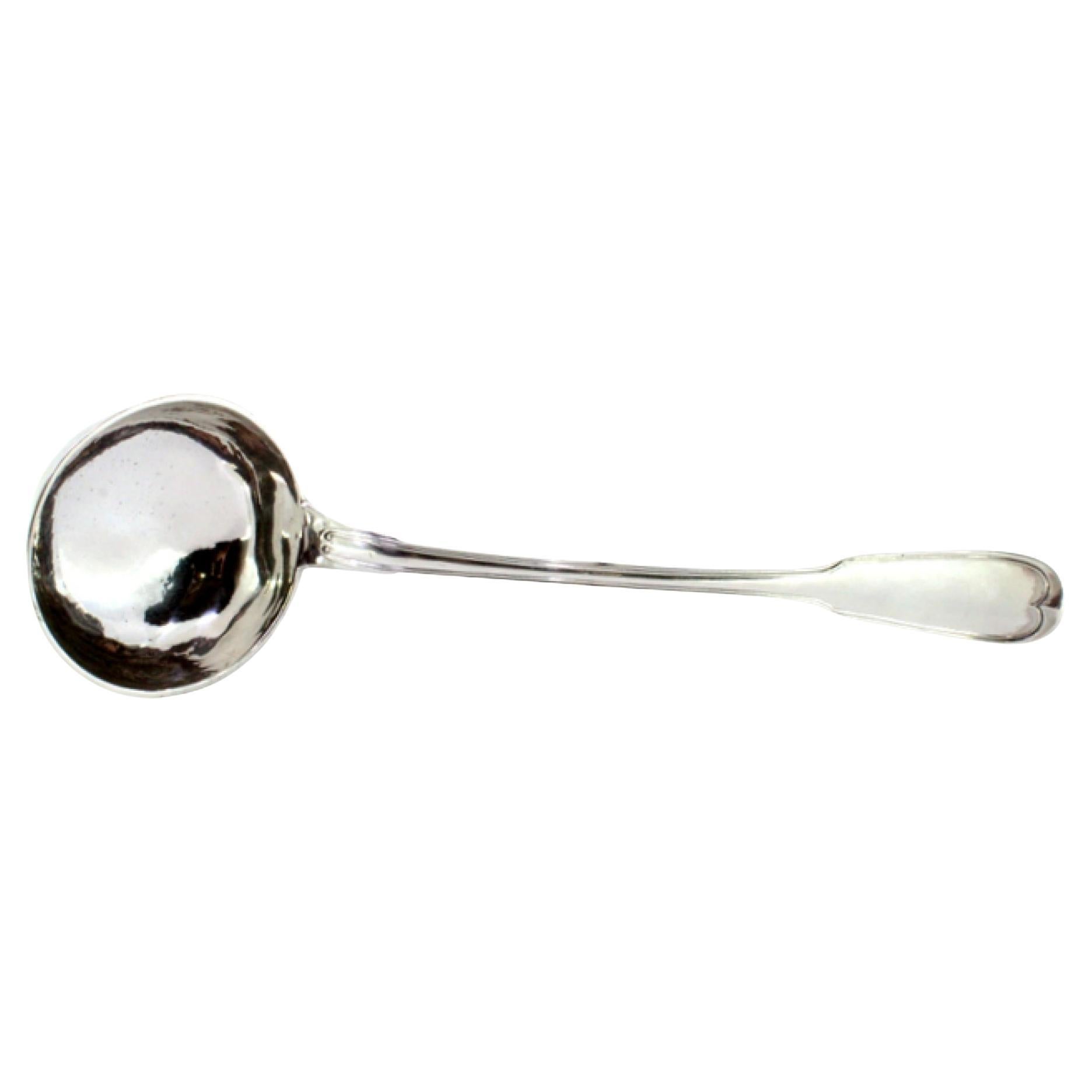 Silver soup ladle with grooves along the handle and monogram plaque