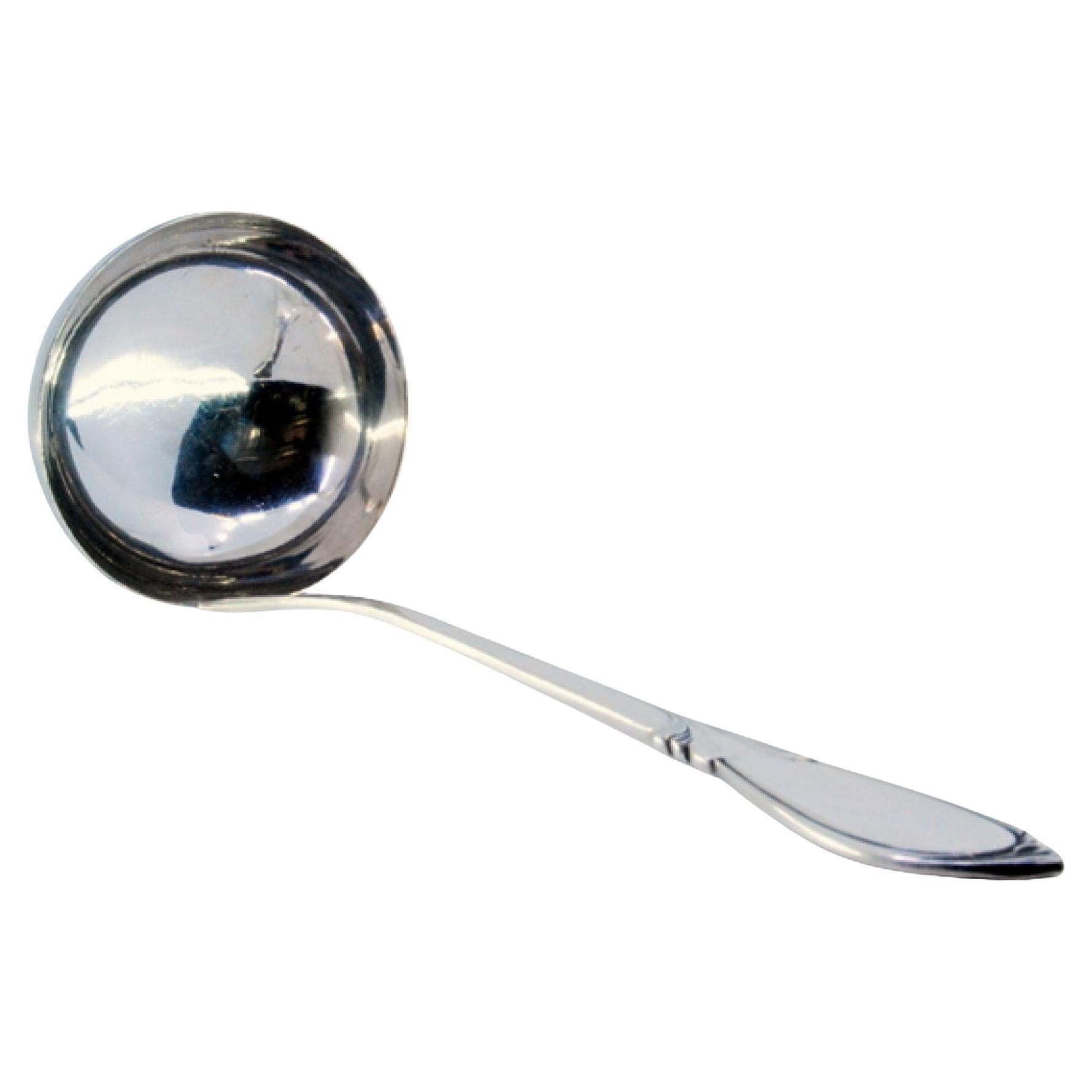 Silver soup ladle with grooves along the handle and monogram plaque