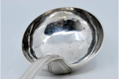 Silver soup ladle with grooves along the handle