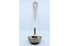 Silver soup ladle with grooves along the handle