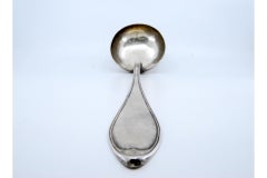 Silver soup ladle with grooves along the handle