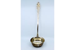 Silver soup ladle with grooves along the handle