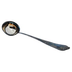 Silberne Suppenkelle mit Rillen entlang des Griffs