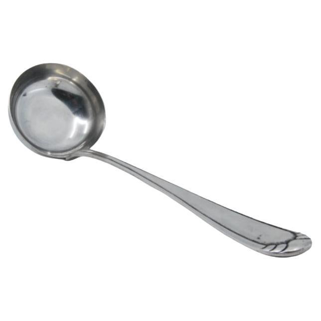 Silver soup ladle with grooves along the handle