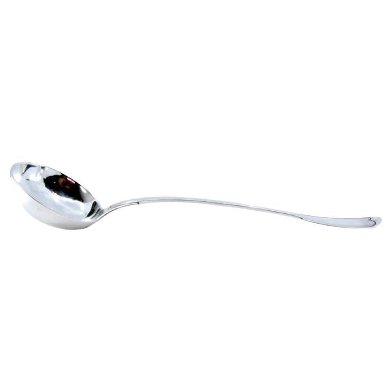 Silver soup ladle with grooves along the handle