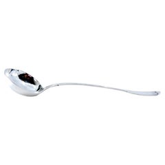 Silver soup ladle with grooves along the handle