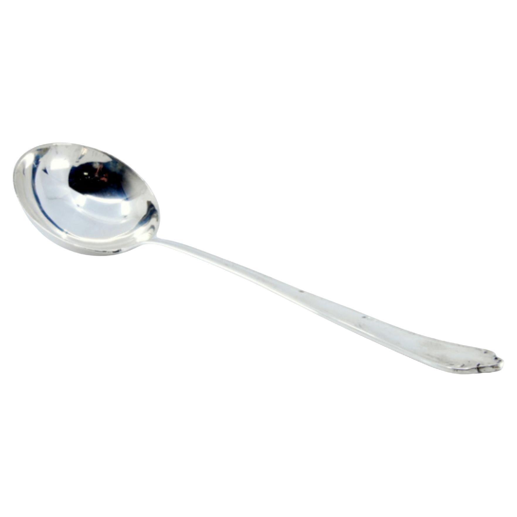 Silver soup ladle with grooves along the handle