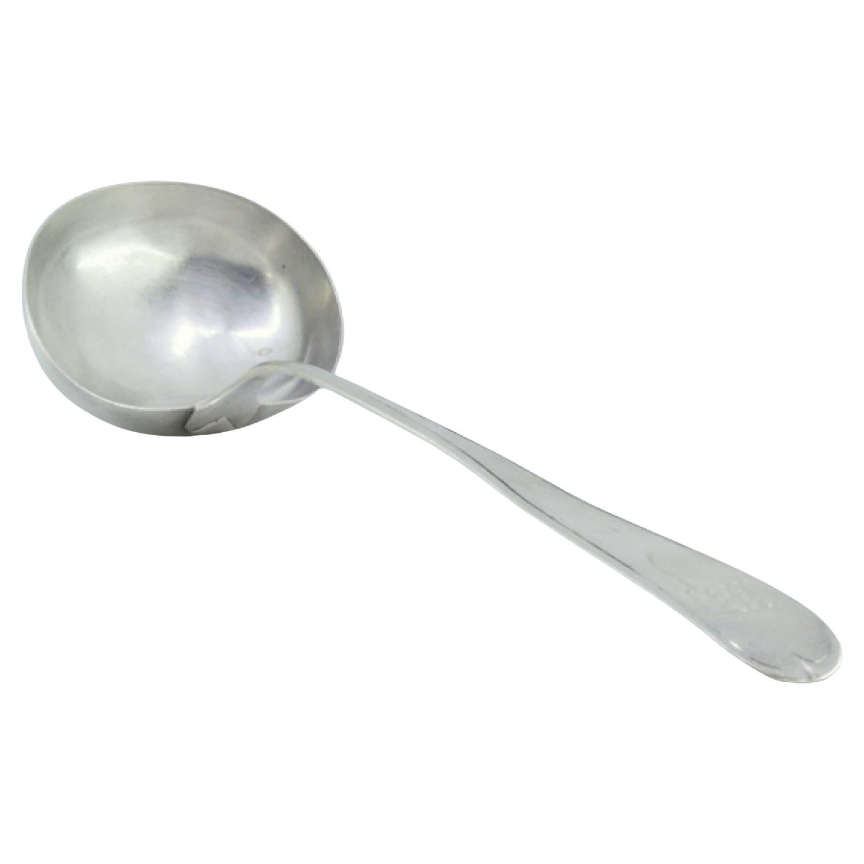 Silver soup ladle with grooves along the handle